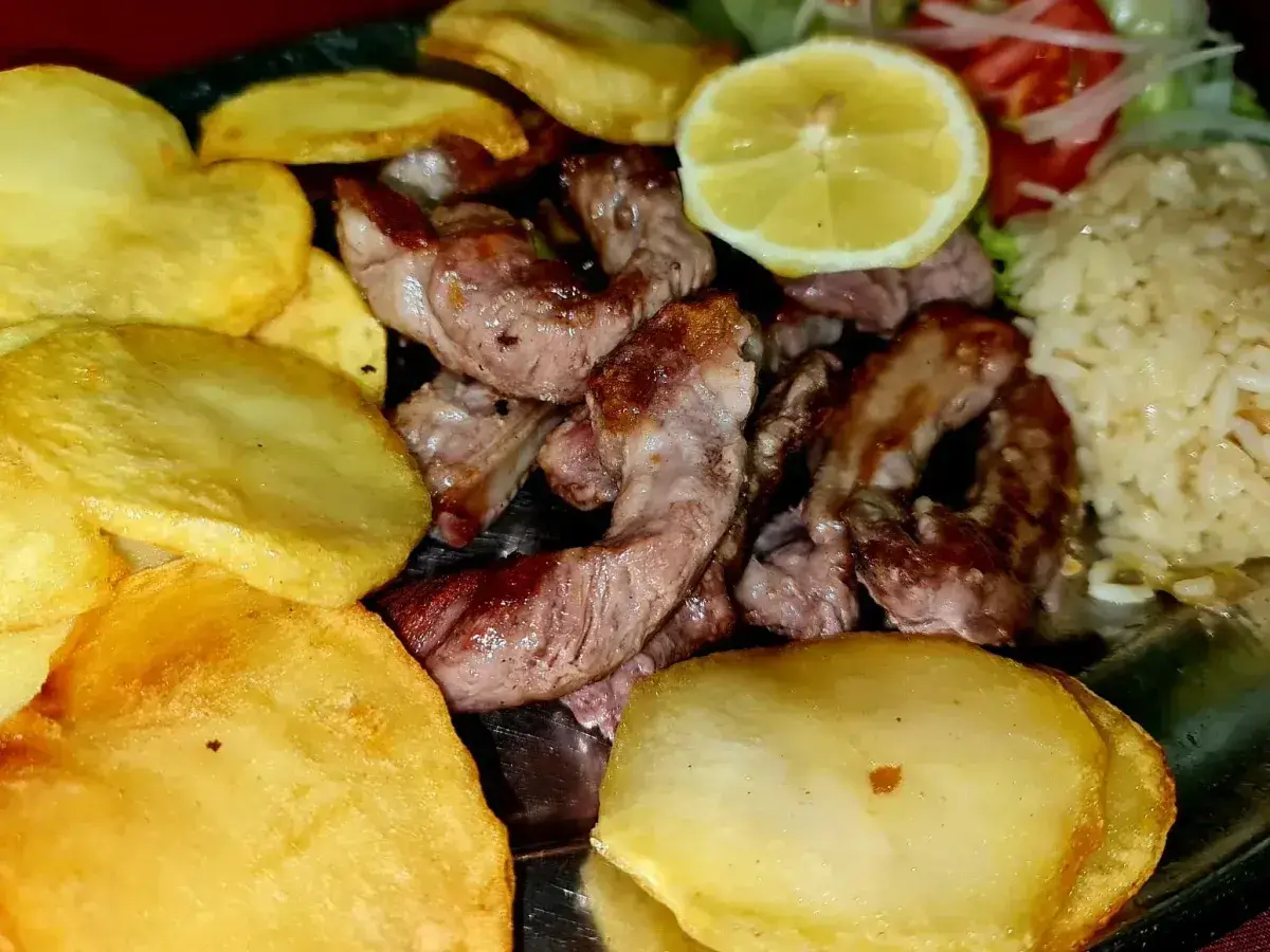 Barbecue di maiale nero con riso e fagioli o patatine fritte