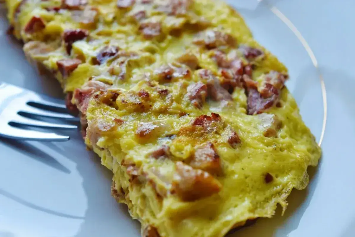 Frittata di carne con prosciutto patatine fritte e insalata mista