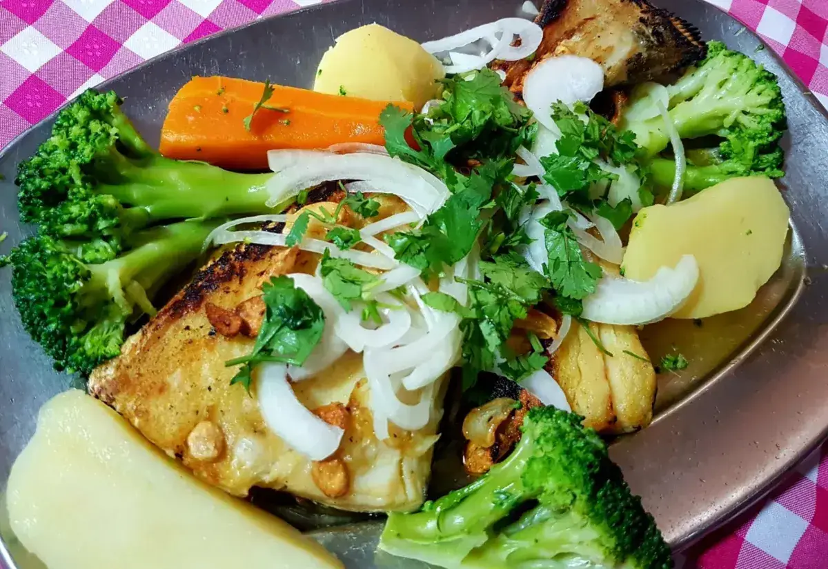Merluzzo cotto in olio caldo e aglio con patate e verdure cotte